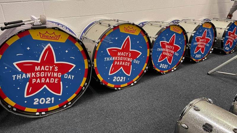 A row of drums lined up with Macy's Thanksgiving Day Parade livery on them
