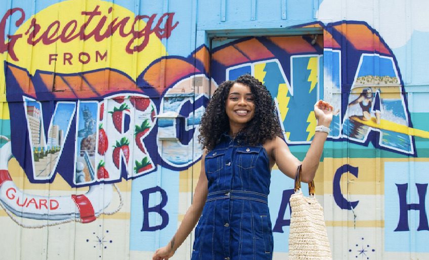 woman smiling in front of mural 