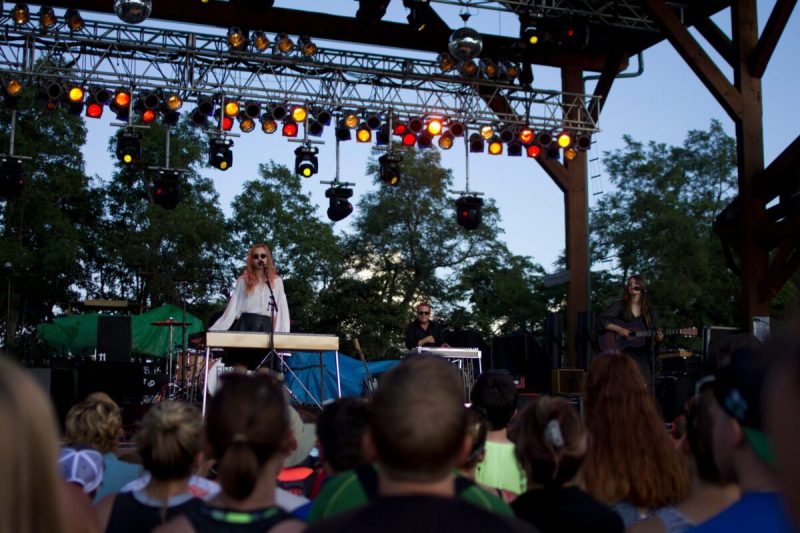 an audience watches a woman singing on stage under lights