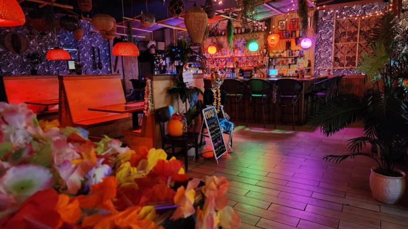 a themed restaurant with flowers, colorful lights, and other Hawaiian decor